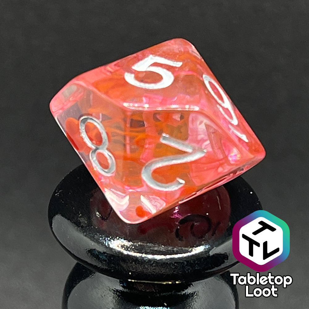 A close up of the D10 from the Healing Potion 7 piece dice set from Tabletop Loot; clear dice with swirls of orange and pink and white numbering.