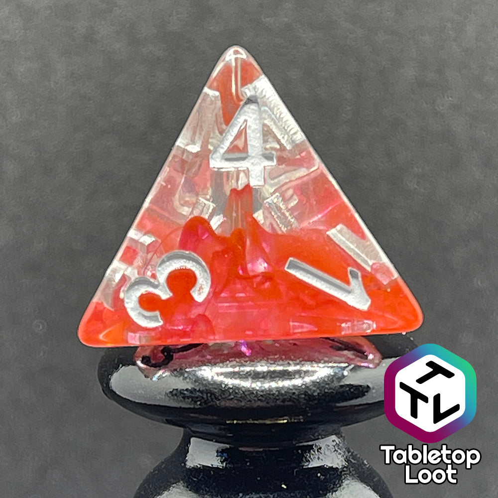 A close up of the D4 from the Healing Potion 7 piece dice set from Tabletop Loot; clear dice with swirls of orange and pink and white numbering.