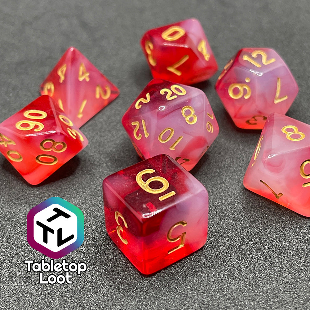 A close up of the Healing Word 7 piece dice set from Tabletop Loot with swirls of white in red and gold numbering.