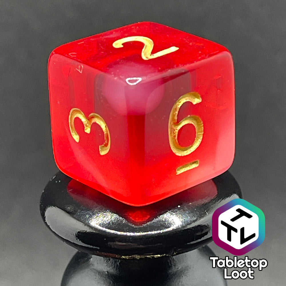 A close up of the D6 from the Healing Word 7 piece dice set from Tabletop Loot with swirls of white in red and gold numbering.