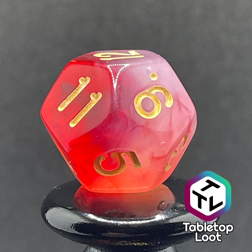 A close up of the D12 from the Healing Word 7 piece dice set from Tabletop Loot with swirls of white in red and gold numbering.