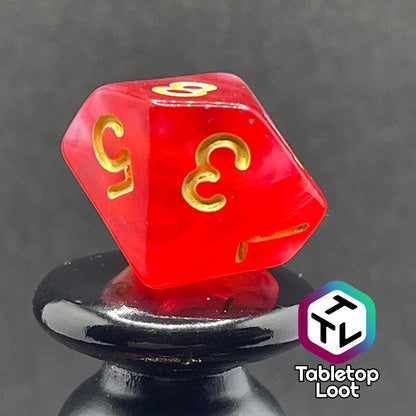 A close up of the D10 from the Healing Word 7 piece dice set from Tabletop Loot with swirls of white in red and gold numbering.