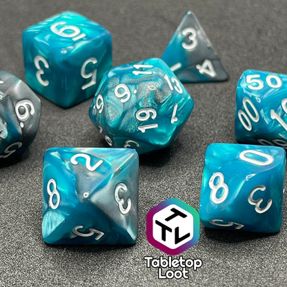 A close up of the Hunter's Mark 7 piece dice set from Tabletop Loot with pearlescent swirls of blue and silver and white numbering.