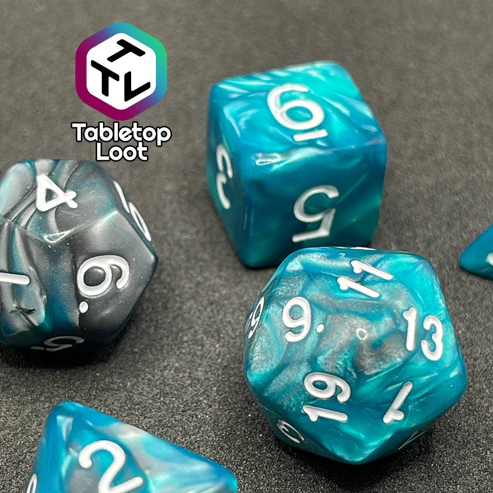 A close up of the Hunter's Mark 7 piece dice set from Tabletop Loot with pearlescent swirls of blue and silver and white numbering.