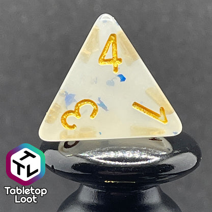A close up of the D4 from the Ice Shards 7 piece dice set from Tabletop Loot with blue metal flakes in milky white resin with gold numbering.