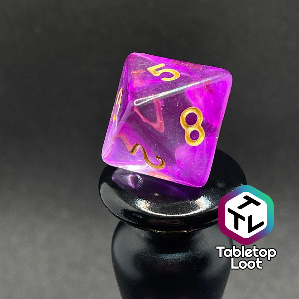 A close up of the D8 from the Incantation 7 piece dice set from Tabletop Loot with swirls of fuchsia in clear and gold numbering.
