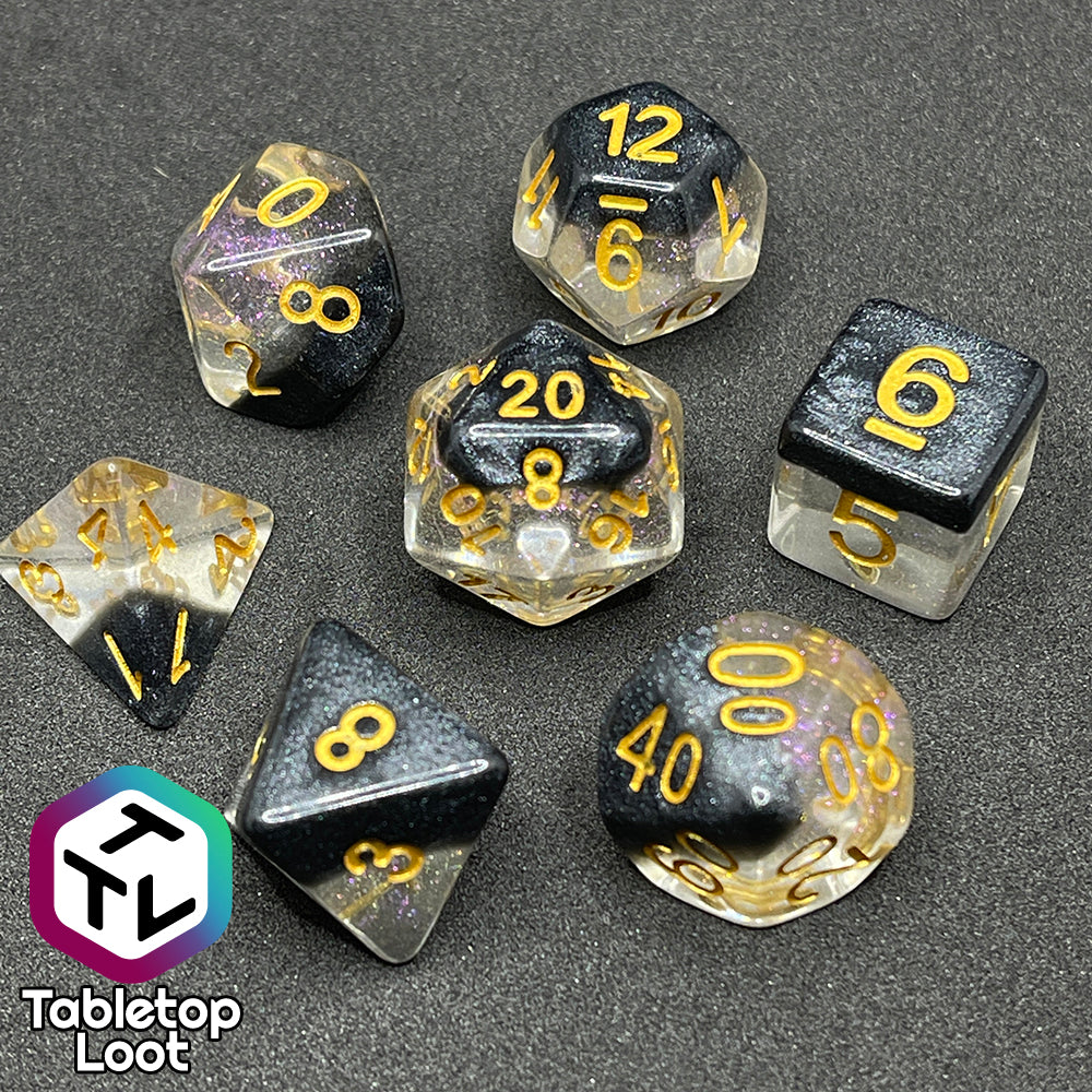 The Inkwell 7 piece dice set from Tabletop Loot with a layer of black glittery color on clear glittery resin and gold numbering.