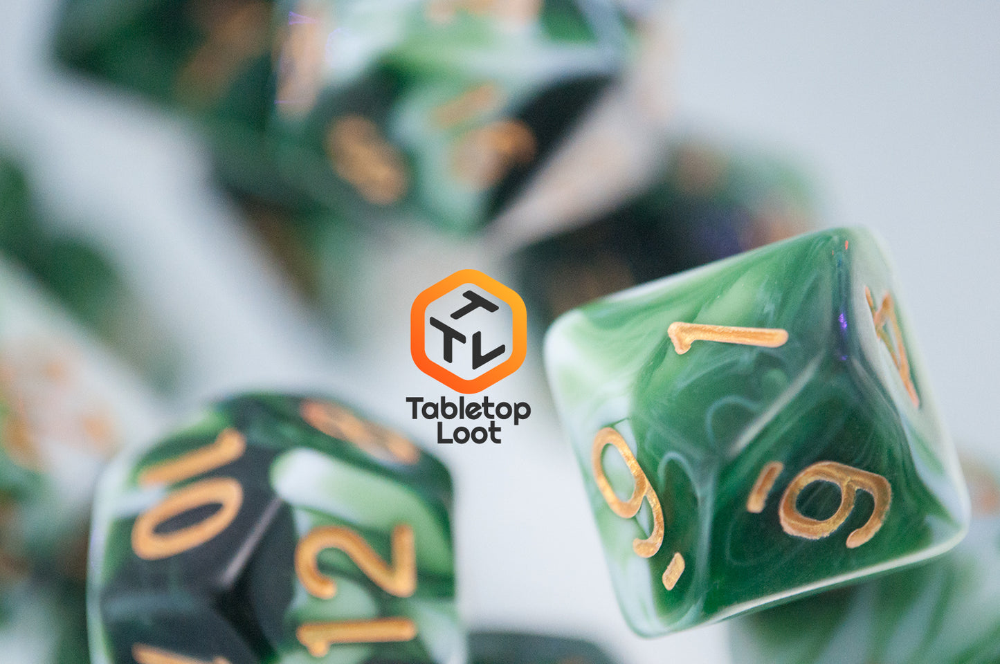 A close up of the D10 from the Jadeite Cabbage 7 piece dice set from Tabletop Loot with swirls of shades of green and white, numbered in gold.