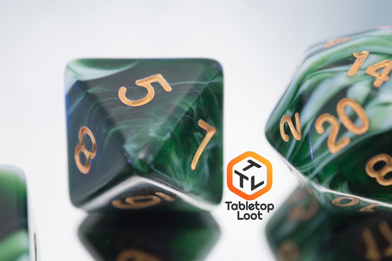 A close up of the D8 from the Jadeite Cabbage 7 piece dice set from Tabletop Loot with swirls of shades of green and white, numbered in gold.
