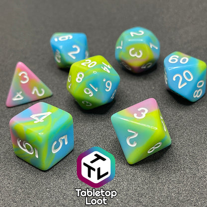 The Jawbreakers 7 piece dice set from Tabletop Loot with swirls of pink, blue, and green and white numbers.