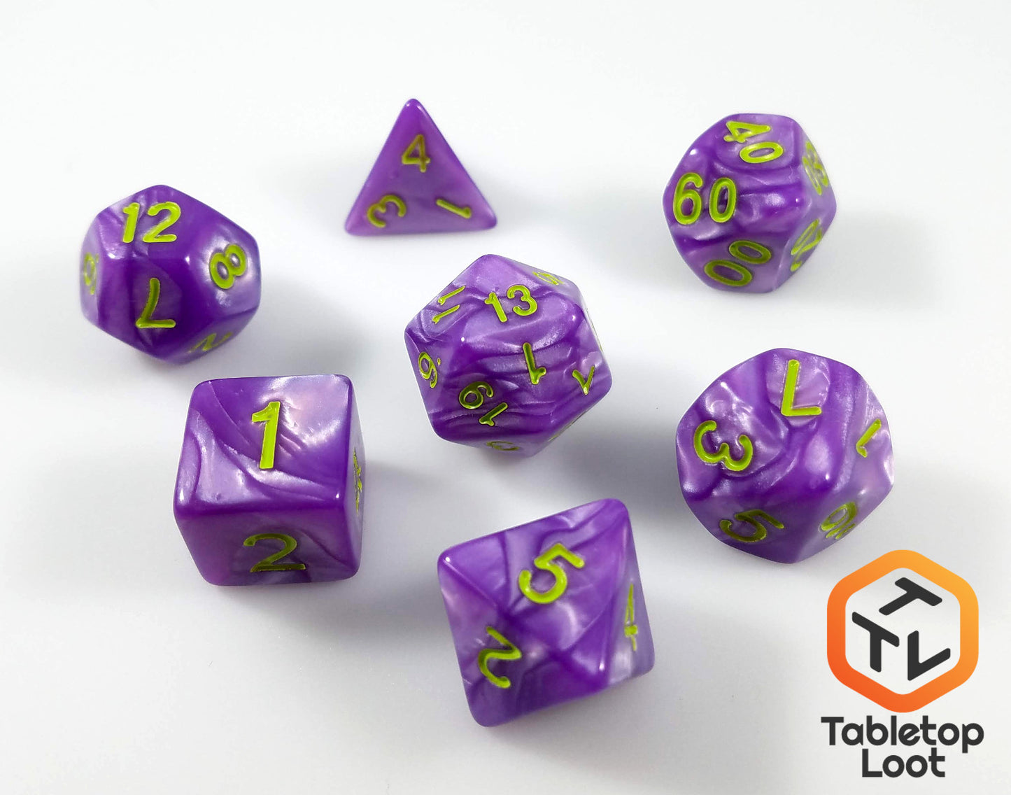 The Joker's Wild 7 piece dice set from Tabletop Loot with swirls of pearlescent purple and bright green numbering.