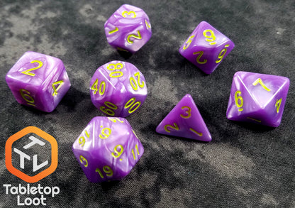The Joker's Wild 7 piece dice set from Tabletop Loot with swirls of pearlescent purple and bright green numbering.