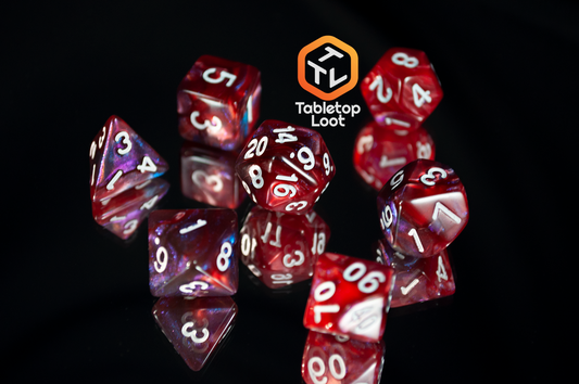The Lava Galaxy 7 piece dice set from Tabletop Loot with swirls of red, blue, and purple with tons of shimmer and white numbers.