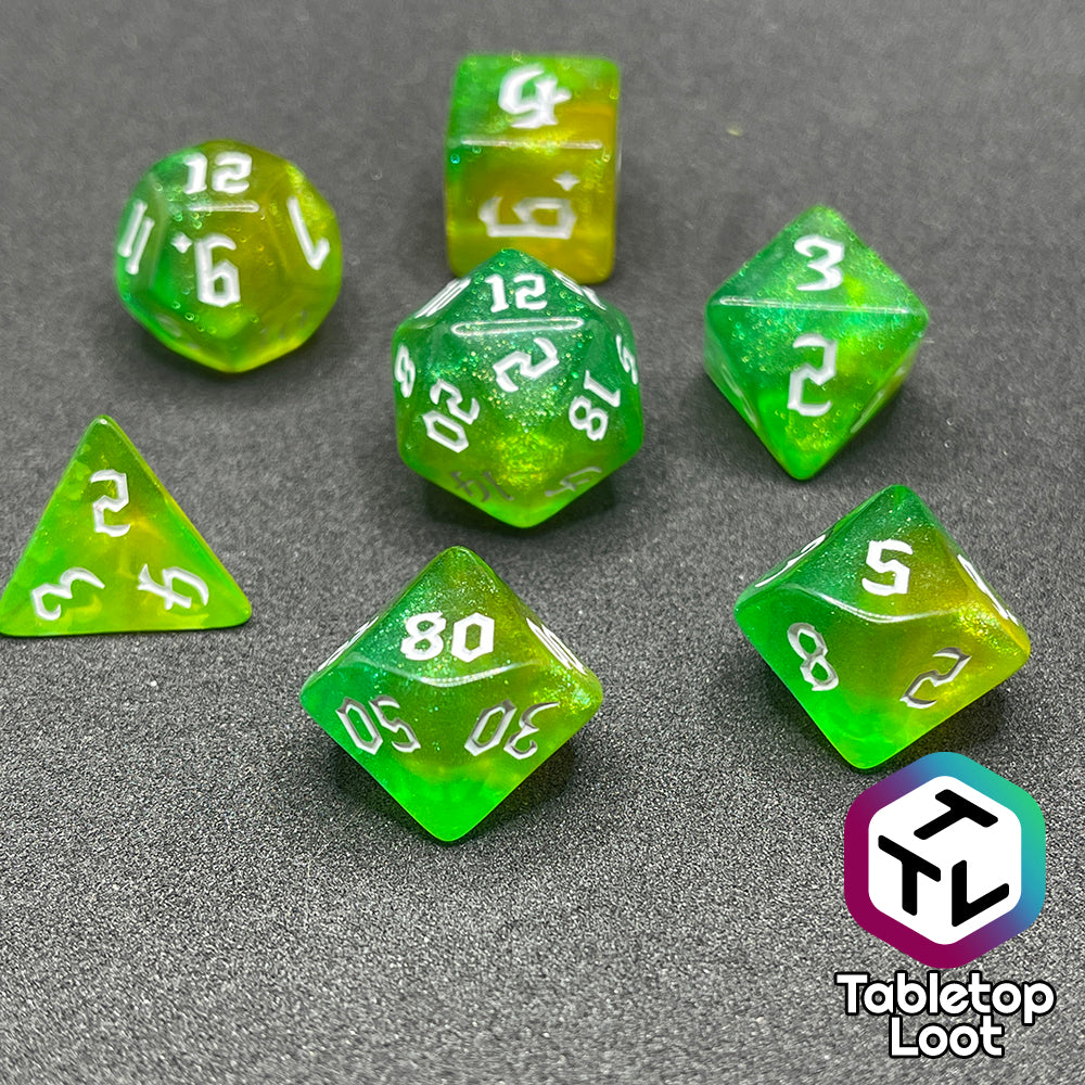 The Luck 7 piece dice set from Tabletop Loot; translucent green and yellow swirled with micro glitter and white gothic numbering.