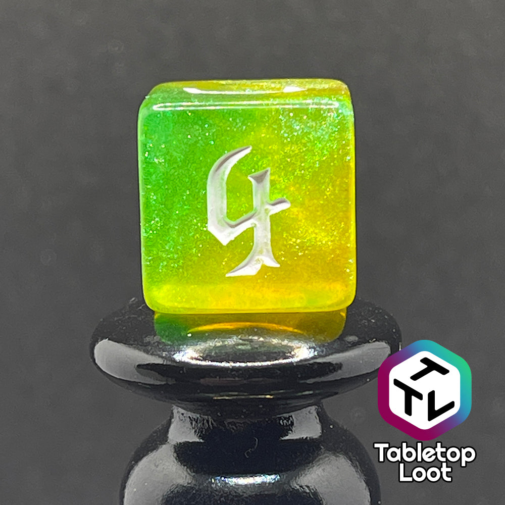 The D6 from the Luck 7 piece dice set from Tabletop Loot; translucent green and yellow swirled with micro glitter and white gothic numbering.
