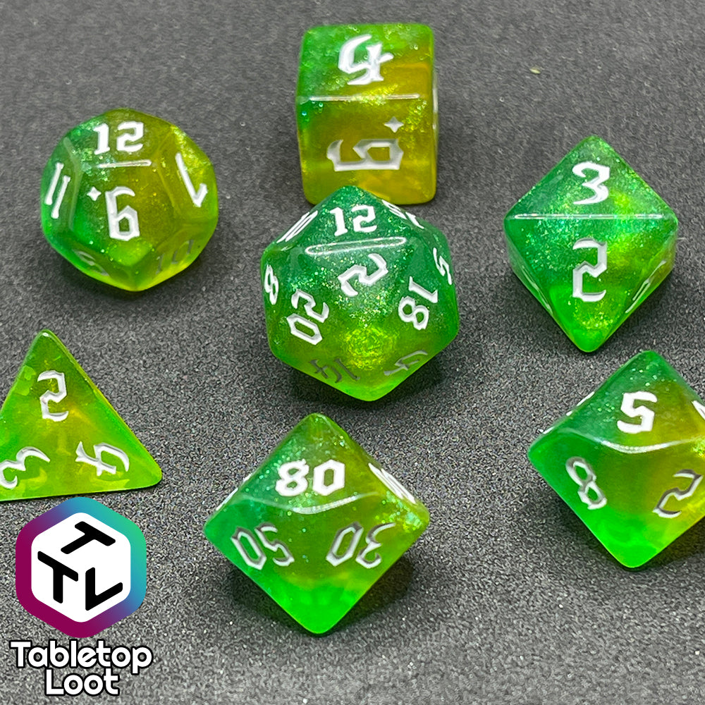The Luck 7 piece dice set from Tabletop Loot; translucent green and yellow swirled with micro glitter and white gothic numbering.