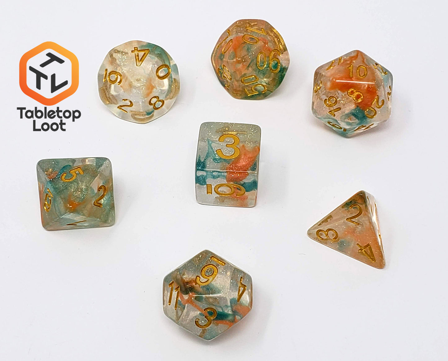 The Luminous Koi 7 piece dice set from Tabletop Loot with swirls of orange and blue in a clear glittery resin with gold numbering.