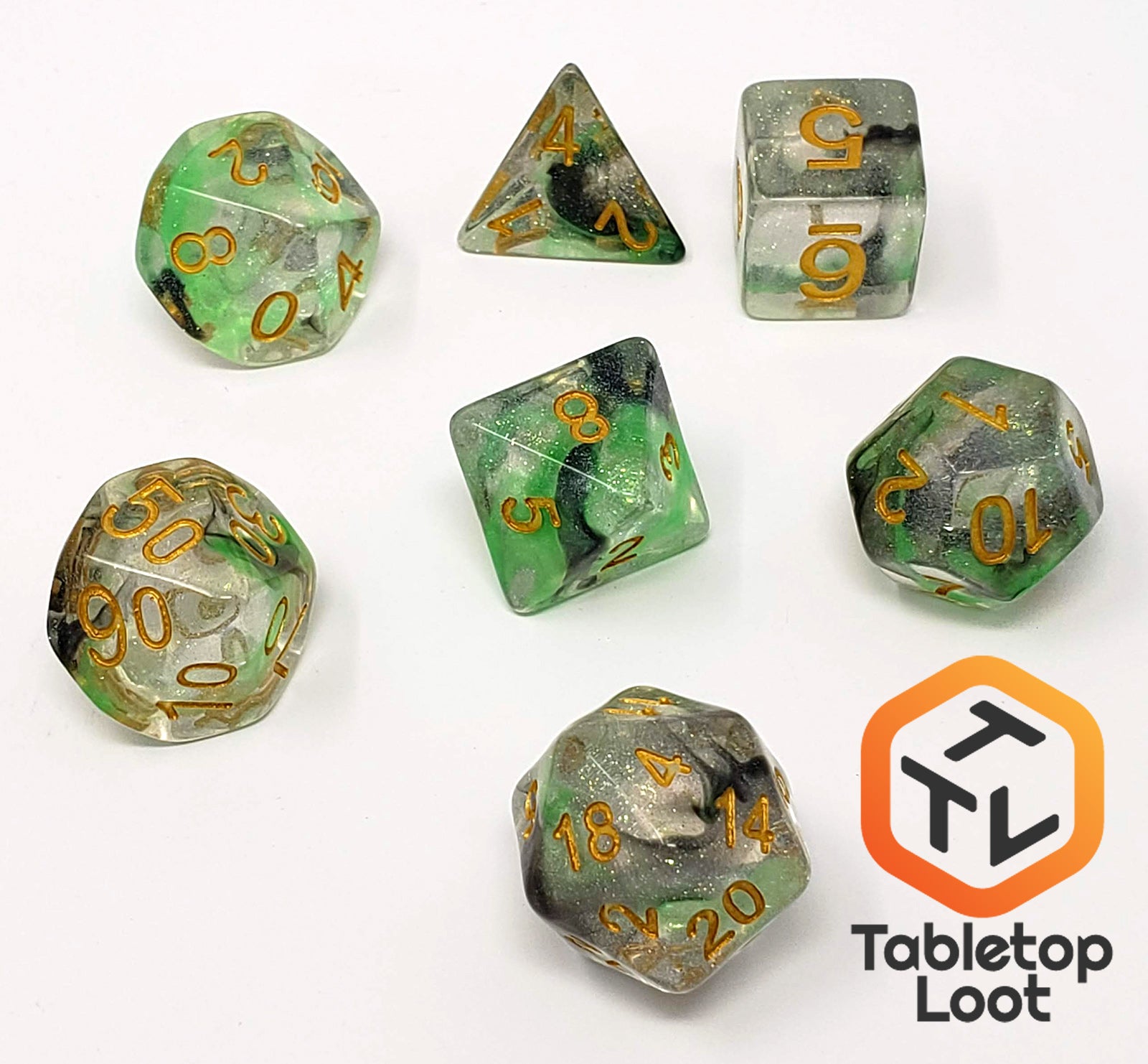 The Luminous Venom 7 piece dice set from Tabletop Loot with green and black swirls in a clear glittery resin with gold numbering.