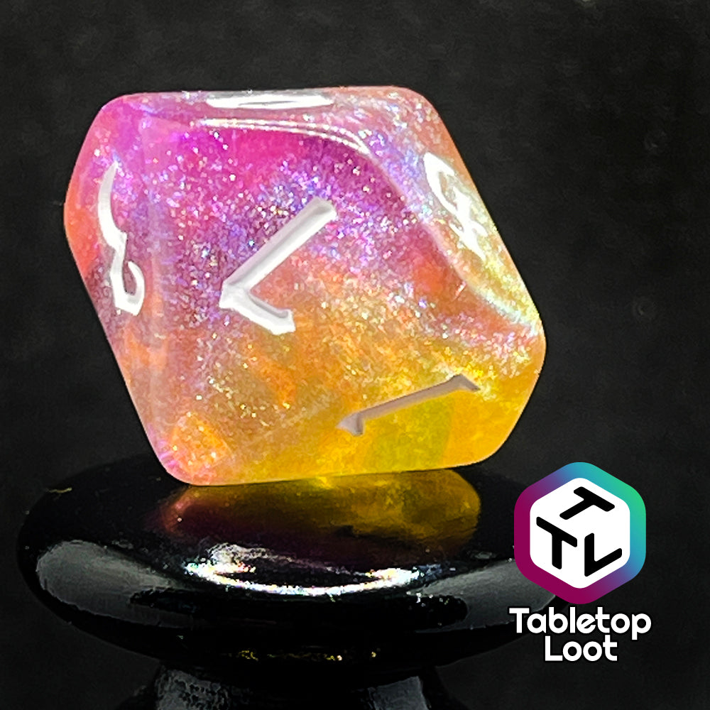A close up of the D10 from the Lunar Tides 7 piece dice set from Tabletop Loot swirling with pink and yellow, packed with glitter, and with white gothic numbering.