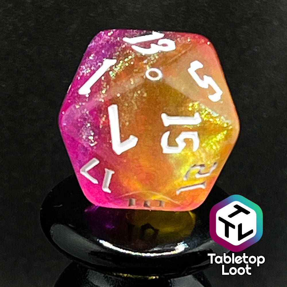 A close up of the D20 from the Lunar Tides 7 piece dice set from Tabletop Loot swirling with pink and yellow, packed with glitter, and with white gothic numbering.