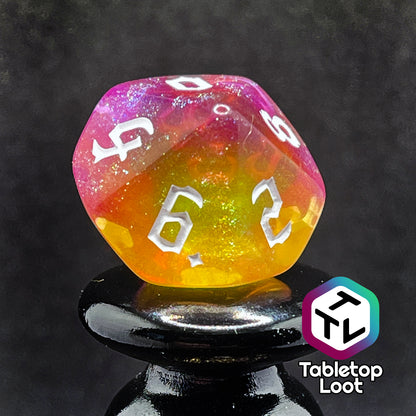 A close up of the D10 from the Lunar Tides 7 piece dice set from Tabletop Loot swirling with pink and yellow, packed with glitter, and with white gothic numbering.