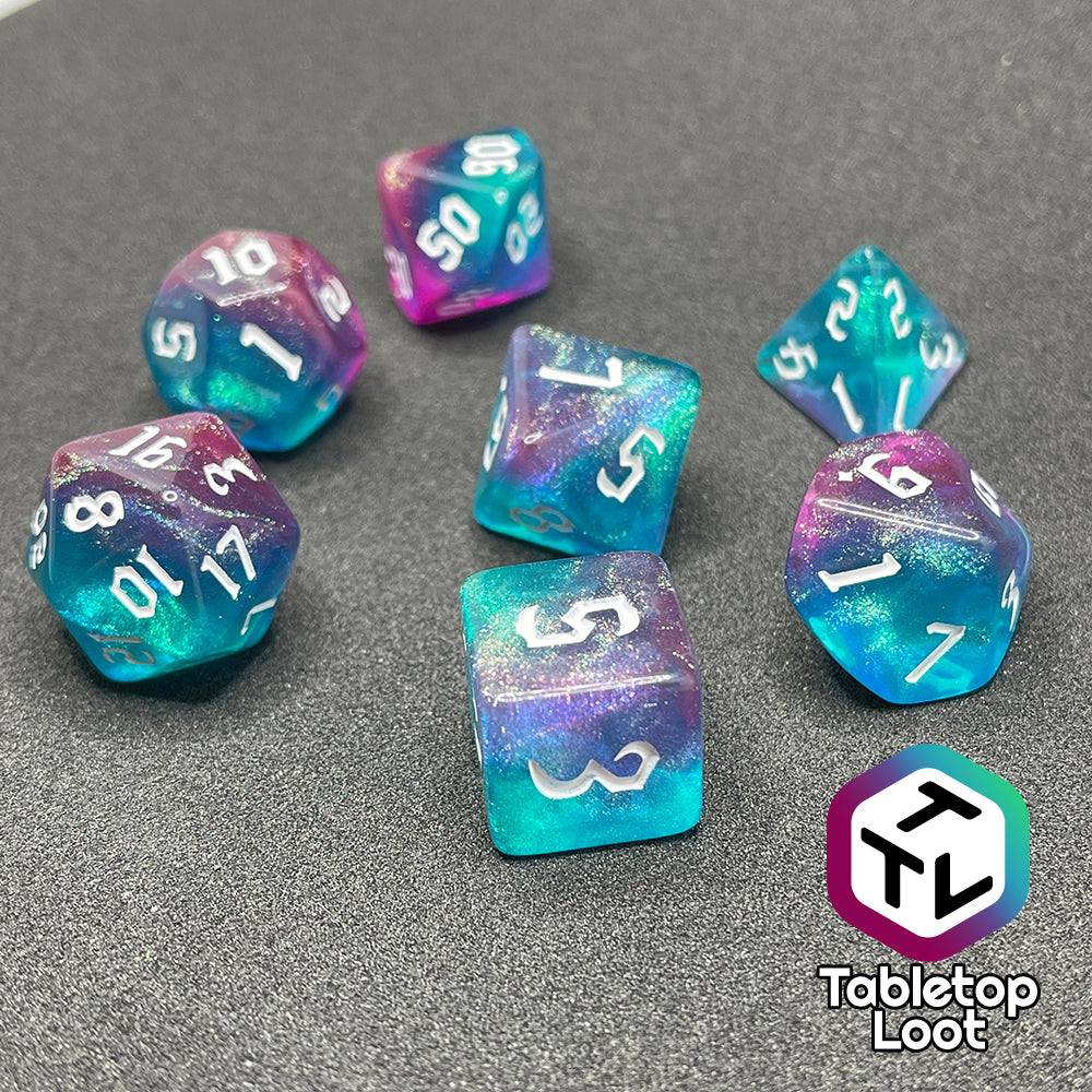 The Mermaid Lagoon 7 piece dice set from Tabletop Loot with shimmery swirls of blue and purple and white gothic numbering.