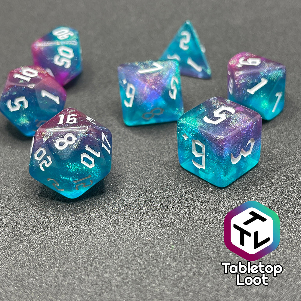 The Mermaid Lagoon 7 piece dice set from Tabletop Loot with shimmery swirls of blue and purple and white gothic numbering.
