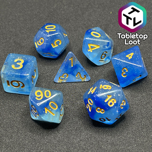 The Mermaid's Crown 7 piece dice set from Tabletop Loot with swirled blue tones, tons of glitter, and gold numbering.