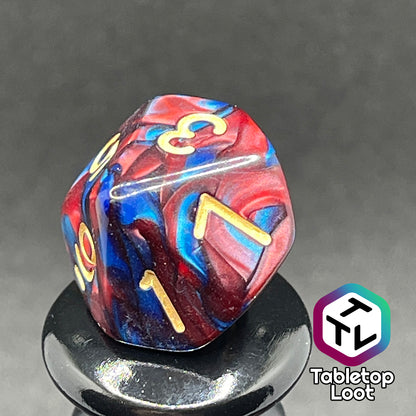 A close up of the D10 from the Metropolis 11 piece dice set from Tabletop Loot with swirls of red and blue and gold numbering.