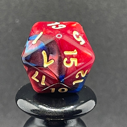 A close up of the D20 from the Metropolis 11 piece dice set from Tabletop Loot with swirls of red and blue and gold numbering.