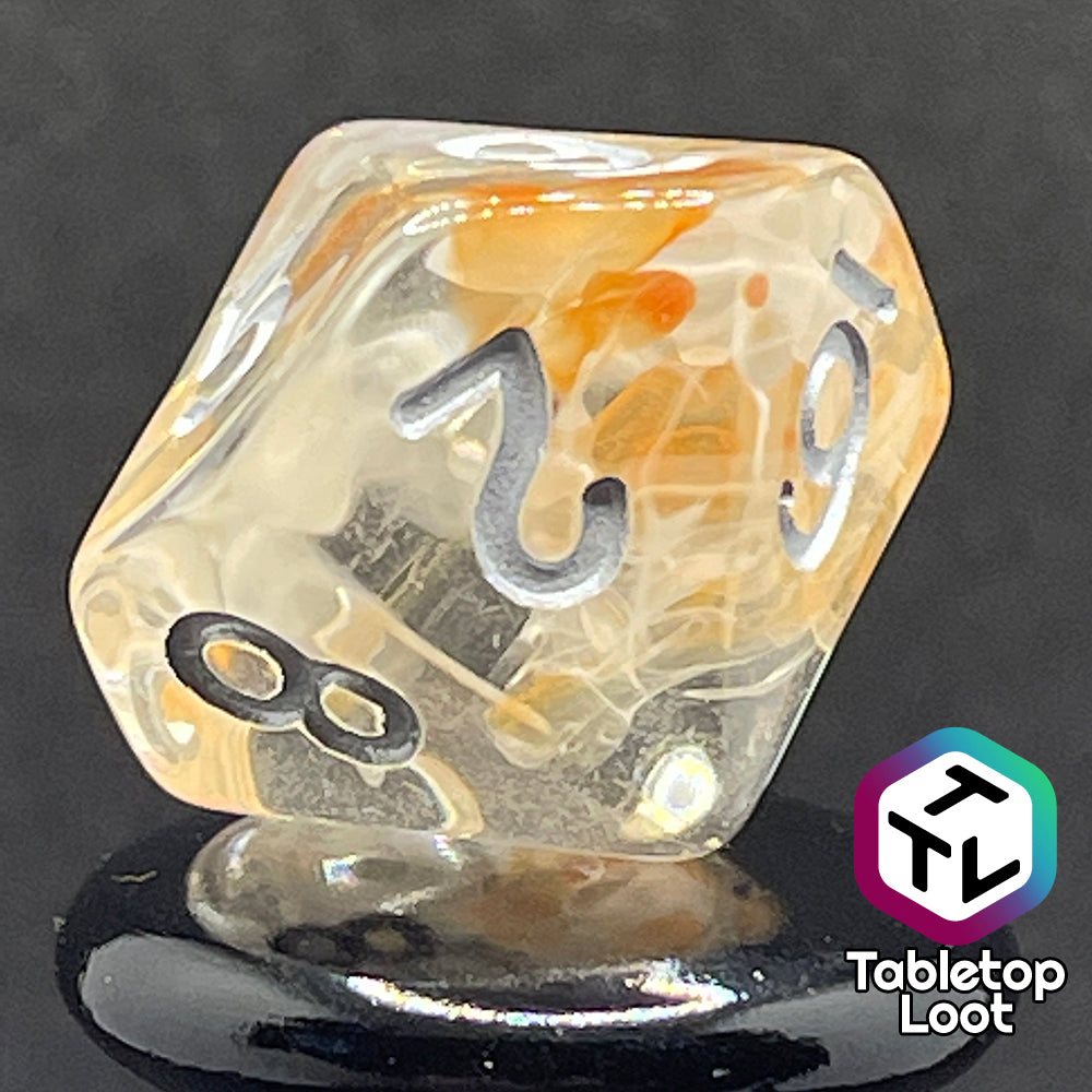 A close up of the D10 from the Hunter's Moon 7 piece dice set from Tabletop Loot with swirls of orange and white in clear resin and white numbering.