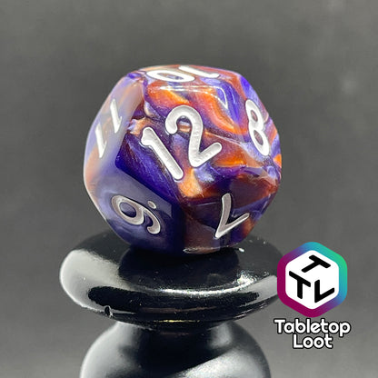 A close up of the D12 from the Mystical Aura 7 piece dice set from Tabletop Loot with swirls of iridescent blue, purple, and orange and white numbering.