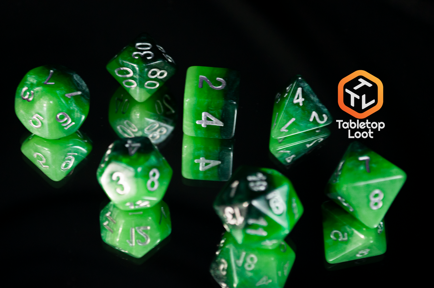 The 7 piece Necropolis dice set from Tabletop Loot with four layered shades of glittery green resin and silver numbering.