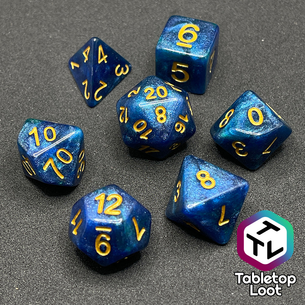 The Neptune's Grace 7 piece dice set from Tabletop Loot with swirls of shimmery blue, hints of green , and gold numbering.