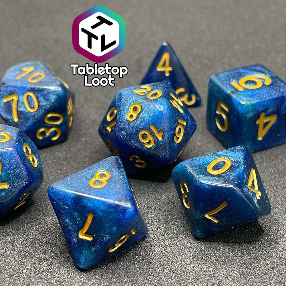 A close up of the Neptune's Grace 7 piece dice set from Tabletop Loot with swirls of shimmery blue, hints of green , and gold numbering.