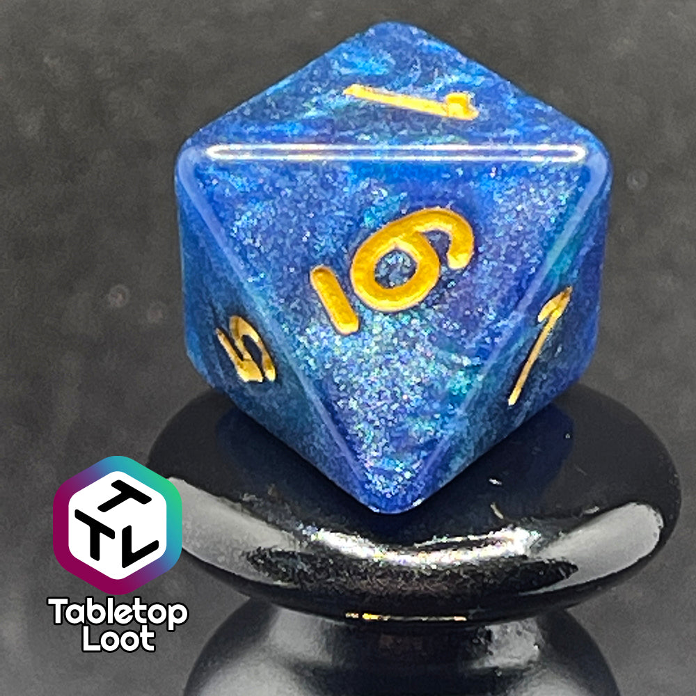 A close up of the D8 from the Neptune's Grace 7 piece dice set from Tabletop Loot with swirls of shimmery blue, hints of green , and gold numbering.