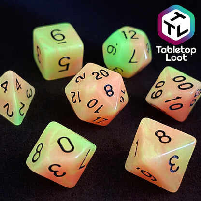 The Nuclear glow in the dark 7 piece dice set from Tabletop Loot with swirls of orange and yellow glow pigment and black numbering, shown glowing.
