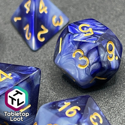 A close up of the D12 from the Order of the Night's Veil 7 piece dice set from Tabletop Loot with swirls of pearlescent purple and white with gold numbering.