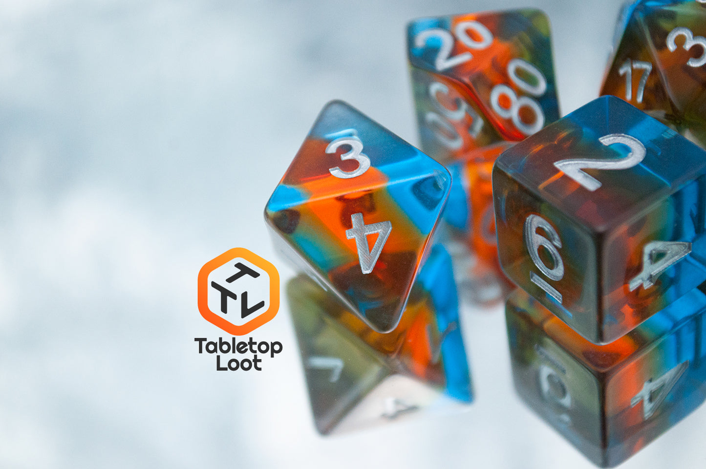 A close up of the Parallel Universes 7 piece dice set from Tabletop Loot with an orange stripe in blue resin and silver numbering.