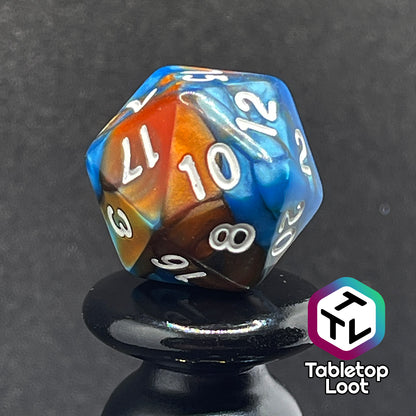 A close up of the D20 from the Patina Copper 7 piece dice set from Tabletop Loot with swirls of pearlescent blue and orange and white numbering.