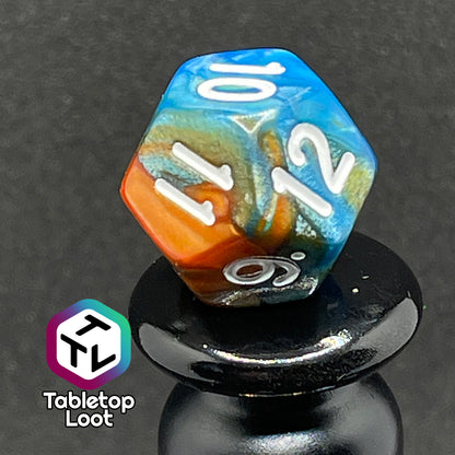A close up of the D12 from the Patina Copper 7 piece dice set from Tabletop Loot with swirls of pearlescent blue and orange and white numbering.