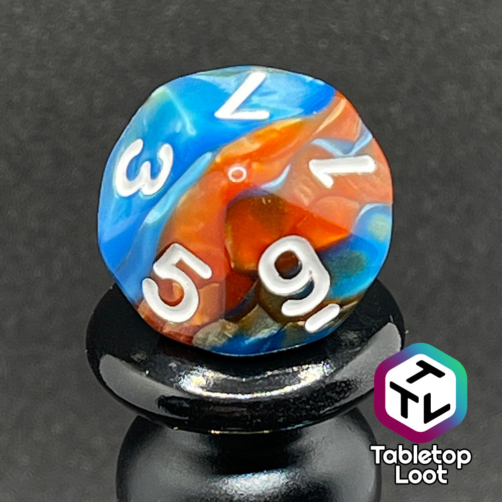 A close up of the D10 from the Patina Copper 7 piece dice set from Tabletop Loot with swirls of pearlescent blue and orange and white numbering.