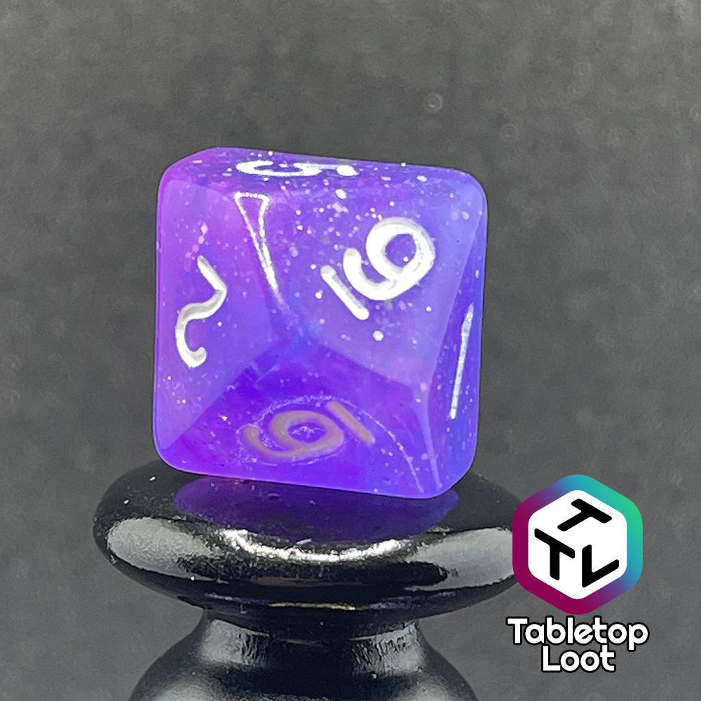 A close up of the D10 from the Phantasmal Force 7 piece dice set with swirls of blue and purple, lots of glitter, and white numbering.