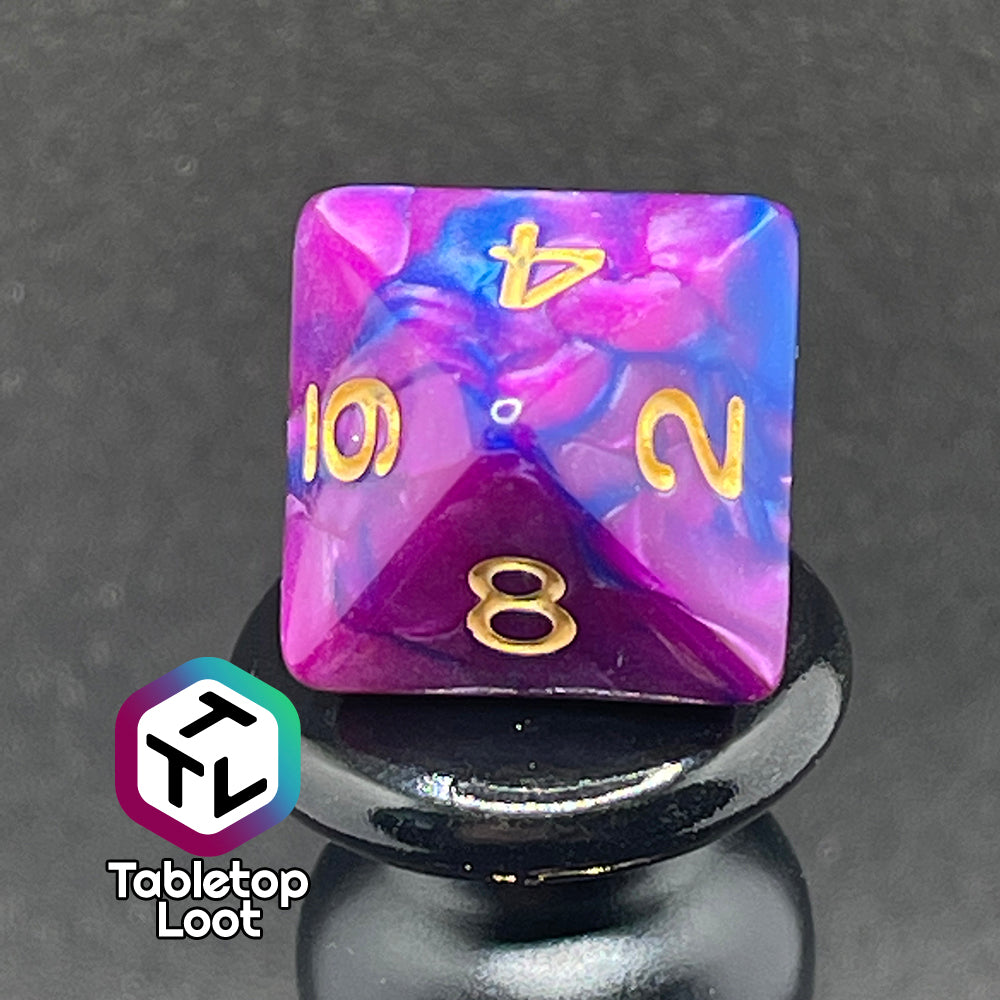 A close up of the D8 from the Spelljammin' 7 piece dice set from Tabletop Loot with pearlescent swirls of purple and blue and gold numbering.