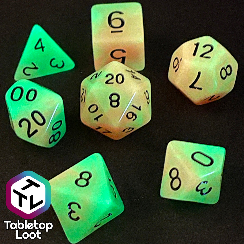 The Neon Nights glow in the dark 7 piece dice set from Tabletop Loot with swirled orange and yellow glow pigment and black numbering, shown glowing.