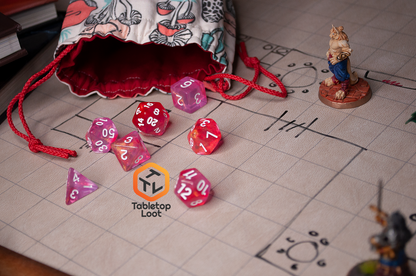 The Pink Bunny 7 piece dice set from Tabletop Loot with yellow and gold shimmer in bright pink resin with white numbering.