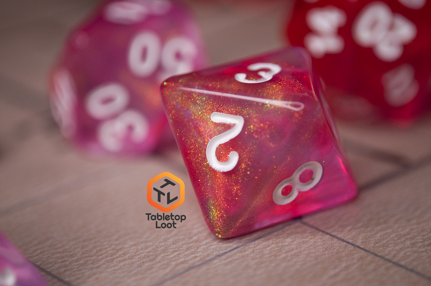 A close up of the D8 from the Pink Bunny 7 piece dice set from Tabletop Loot with yellow and gold shimmer in bright pink resin with white numbering.