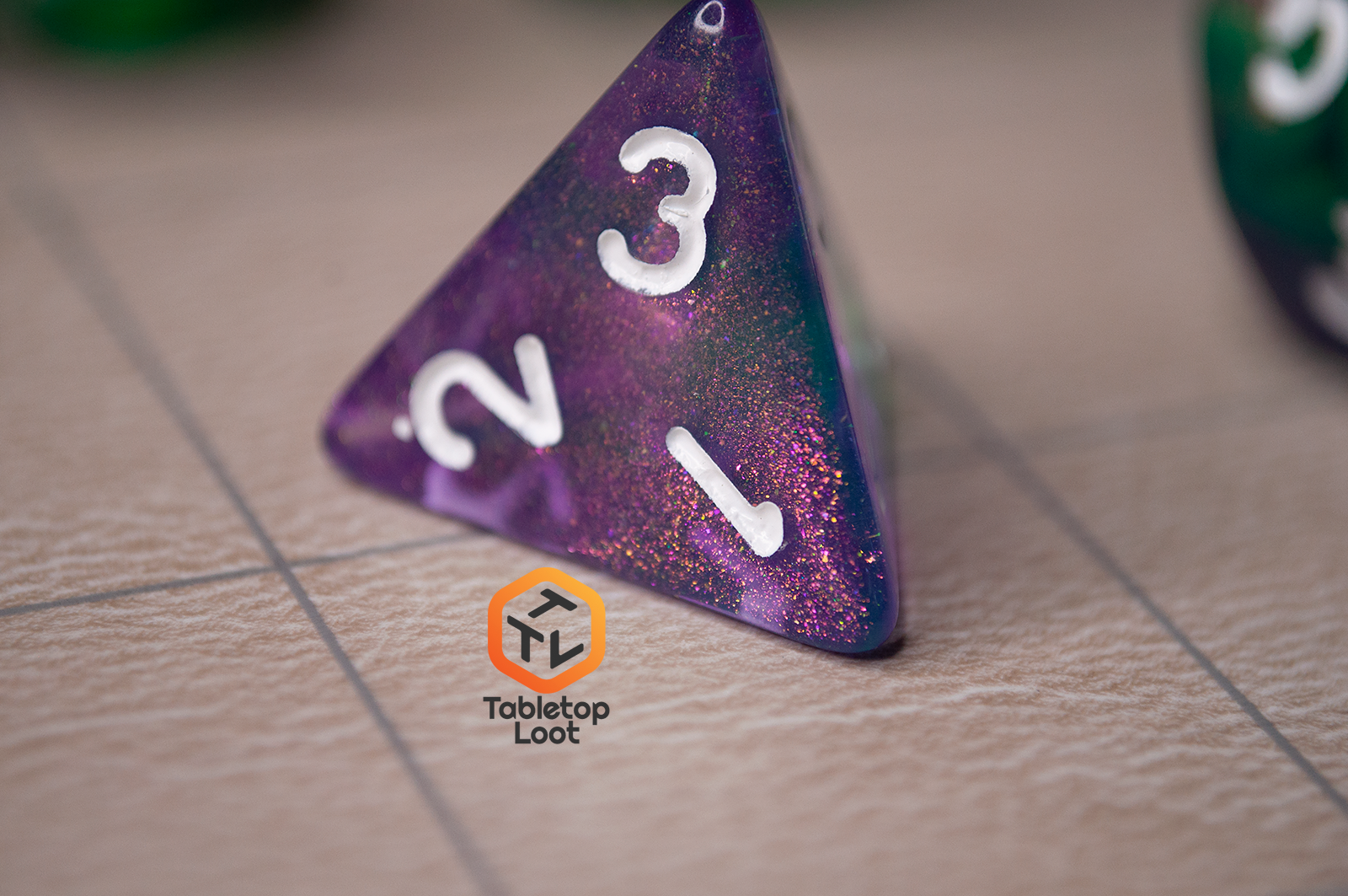A close up of the D4 from the Witch's Brew 7 piece dice set from Tabletop Loot with purple and green shimmery swirls and white numbering.
