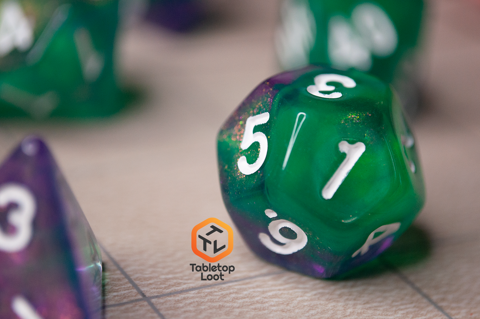 A close up of the D12 from the Witch's Brew 7 piece dice set from Tabletop Loot with purple and green shimmery swirls and white numbering.