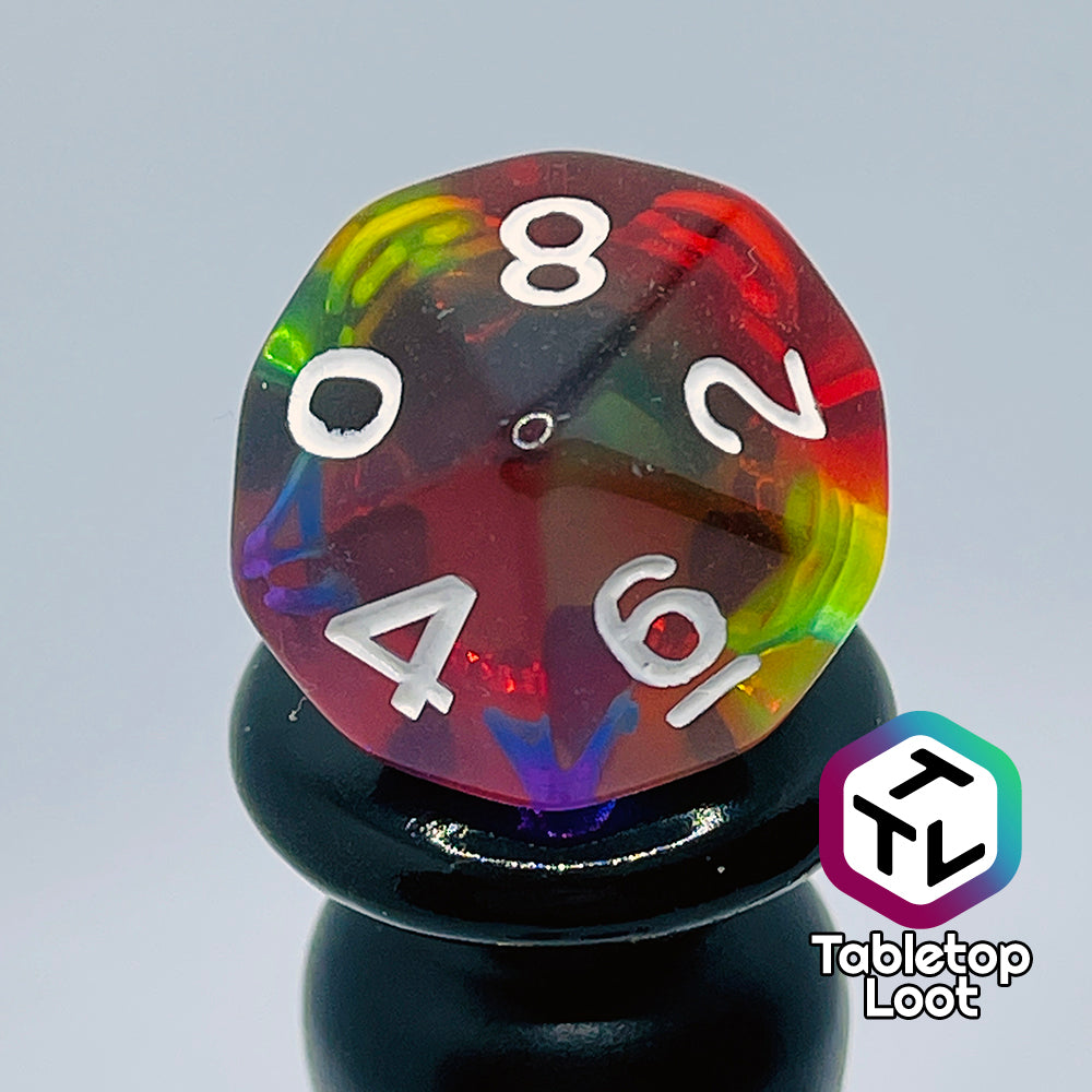 A close up of the D10 from the Pride 7 piece dice set from Tabletop Loot with stripes of translucent colors in rainbow order and white numbering.
